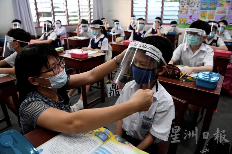 老师亲自为学生带上面罩，确保达到最佳的防疫效果。