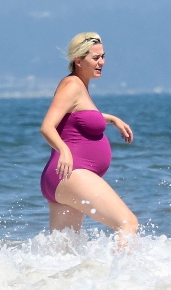 凯蒂穿着紫色泳装到海边戏水。

