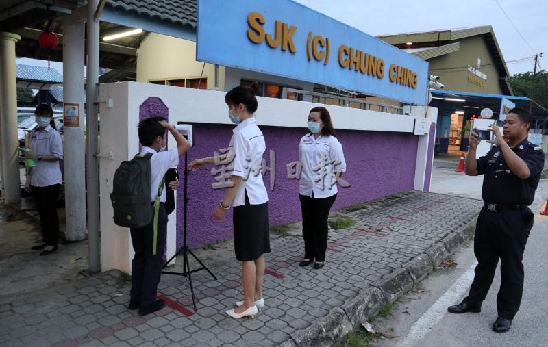 校长古诗敏(右二)与警方校园联络官于校门处，监督学生返校情况，确保大家都遵守防疫SOP。