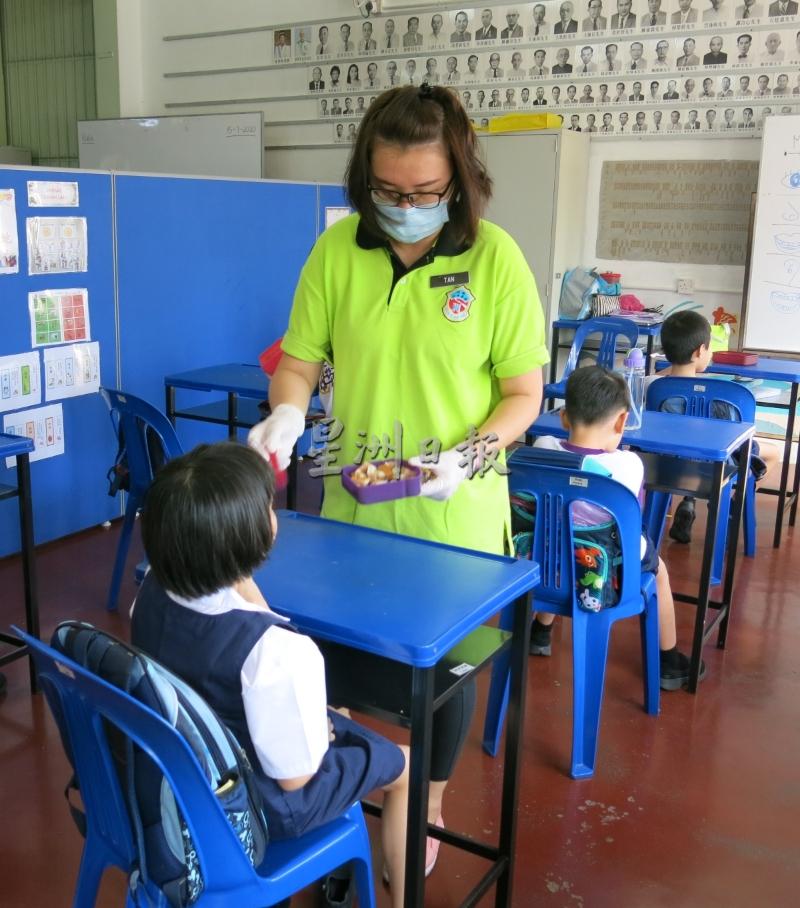 课间休息时，特殊教育班教师戴上口罩及手套，为有特别情况的特殊生喂食餐点。