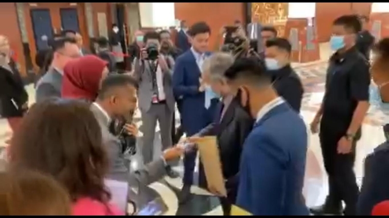 马哈迪在国会走廊向工作人员派发免费口罩。