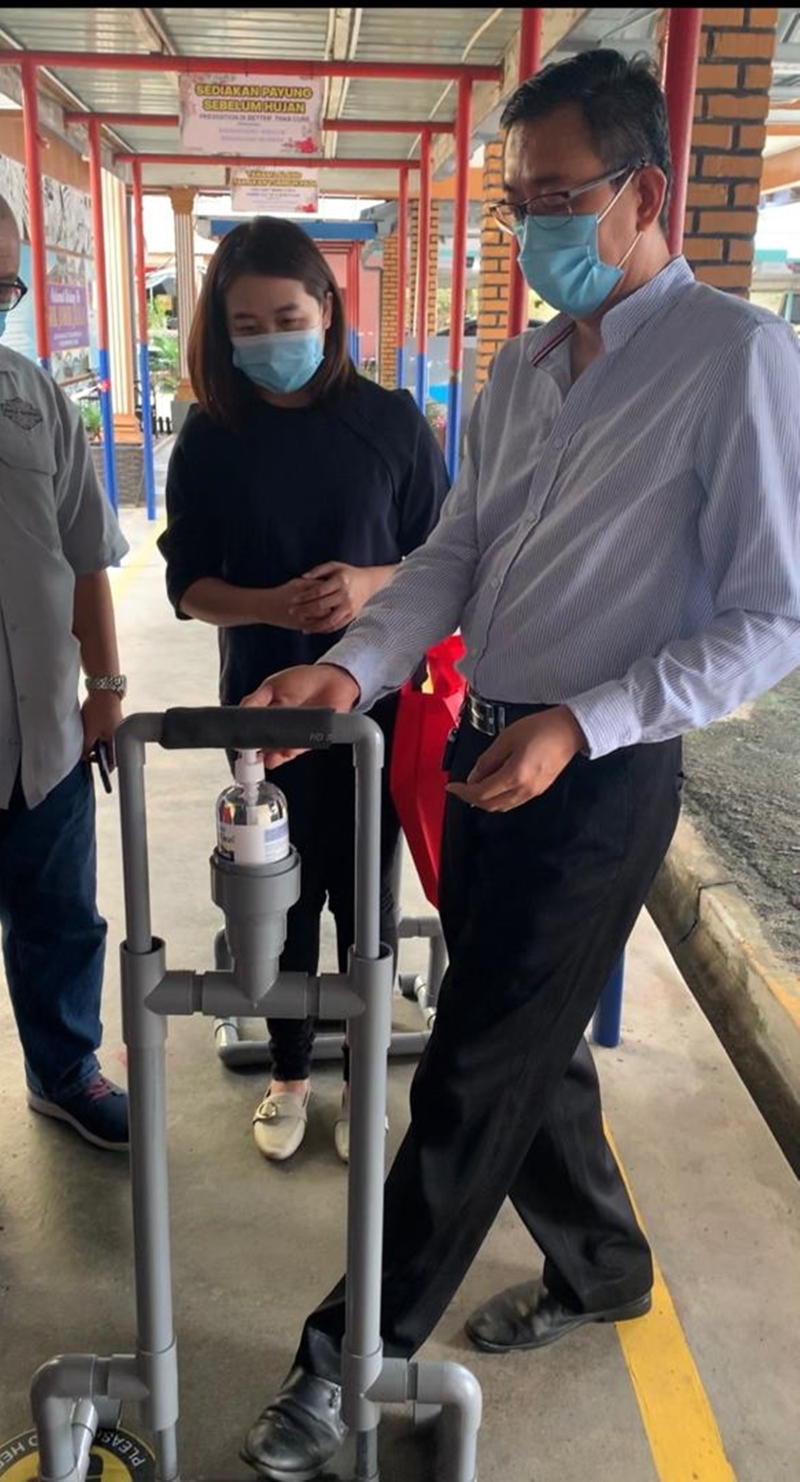 廖彩彤（右二）参观校方采用的脚踏式消毒搓手液支架。