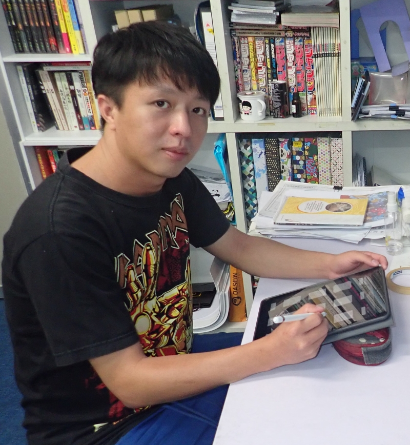 蓝国清在工作室里，以平板电脑绘画漫画。