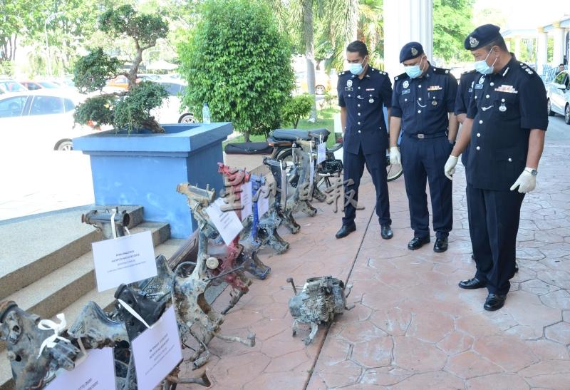沙菲宜（右一）在威中警察总部警官的陪同下，查看起获的失窃摩哆车残骸。