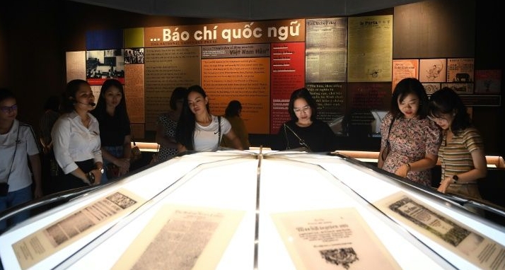 Visitors read historic press articles and newspaper prints displayed at the new museum. AFP