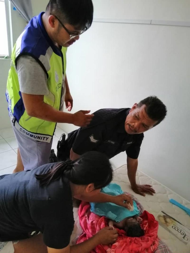 巴占志愿治安公会一名女队员替婴儿抹身。