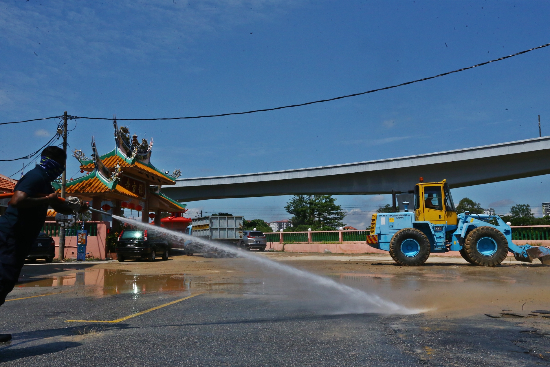 市议会人员用强力喷水机清理师爷宫外面的黄泥巴。