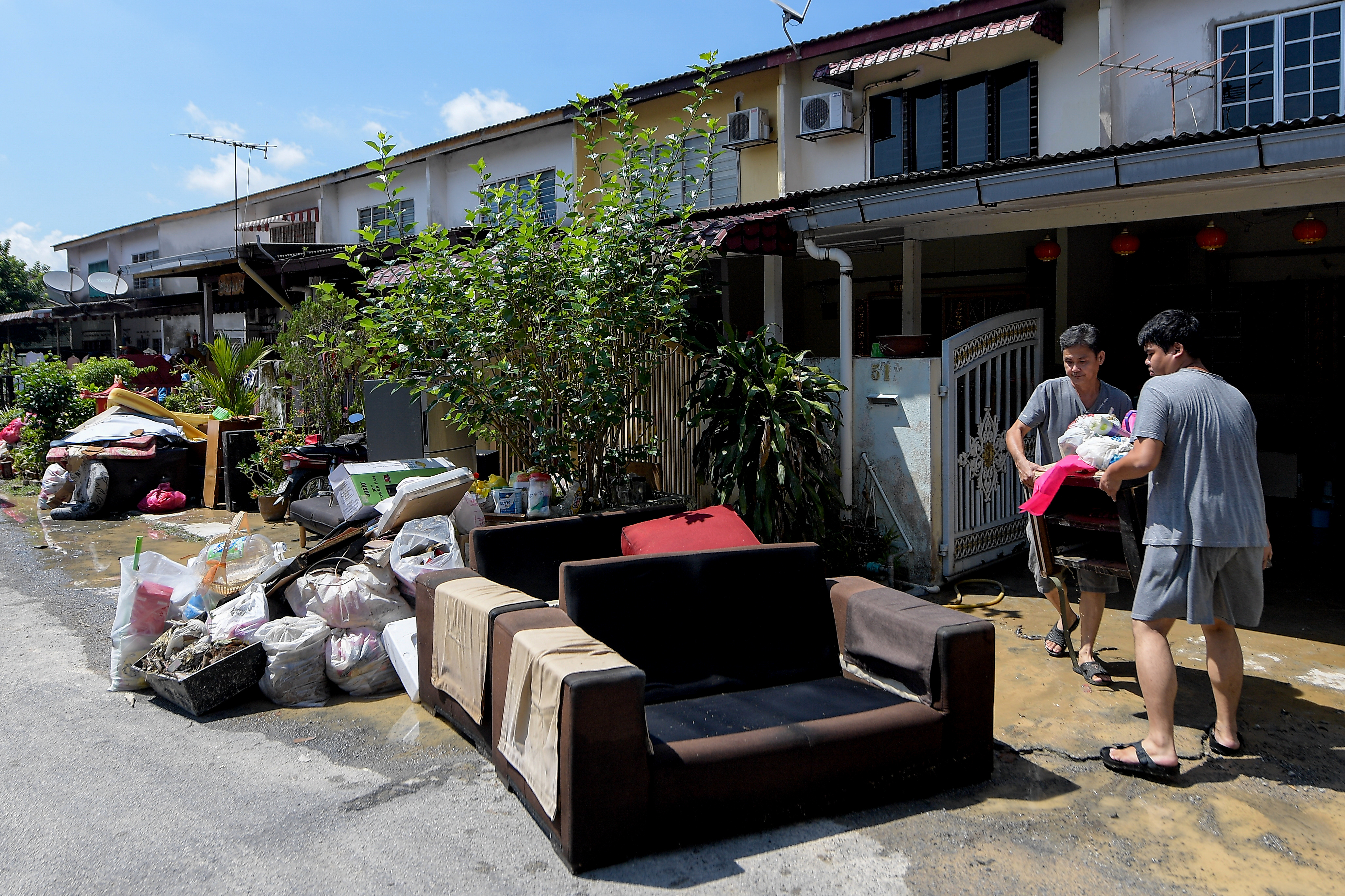 居民把不能要及损坏的家具与电器搬到外面准备丢弃。