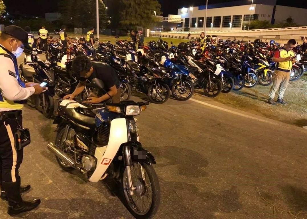 警方检查摩哆车和骑士，并发出罚单给违例者（取自Penang Kini）。