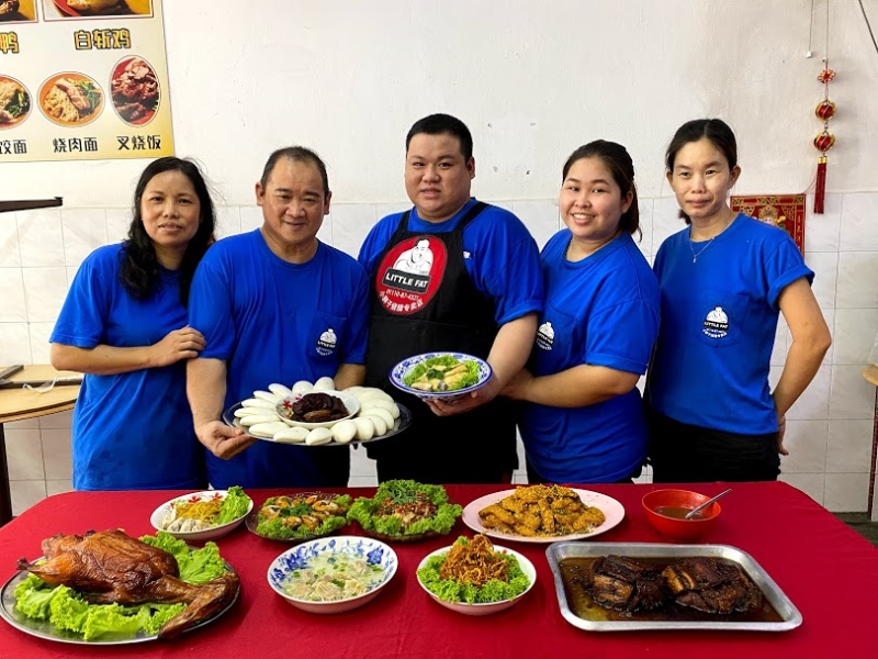 谢强进（中）与母亲陈心颜（左起）、父亲谢志平、员工阿娜（右起）及妻子杨威妮一起向读者介绍店里的招牌美食。