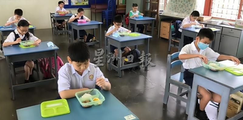 双溪泗里中华小学的学生在教室中进餐。