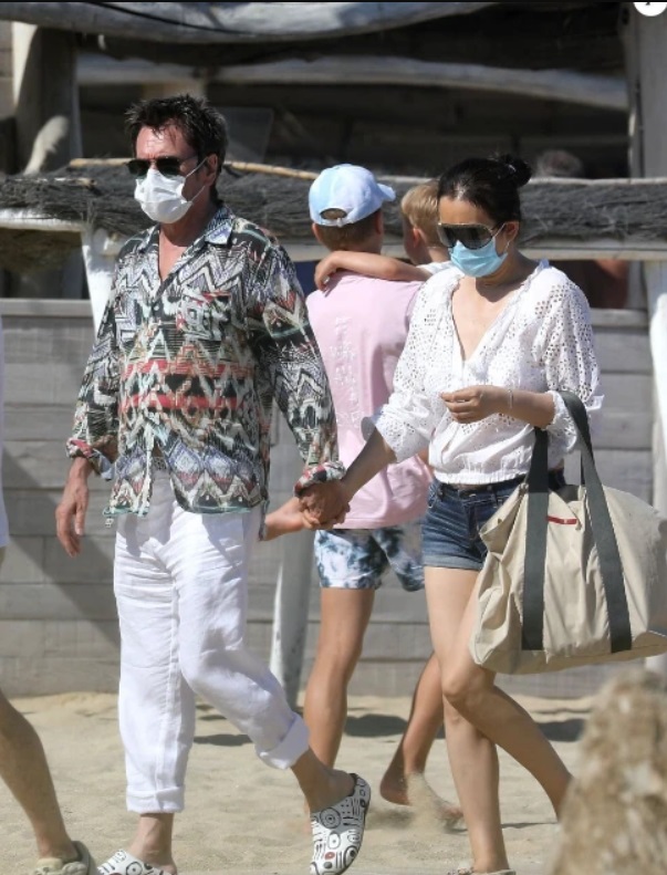 巩俐被拍到和71岁法国老公现身沙滩，戴口罩的两人外表冻龄，还全程十指紧扣。