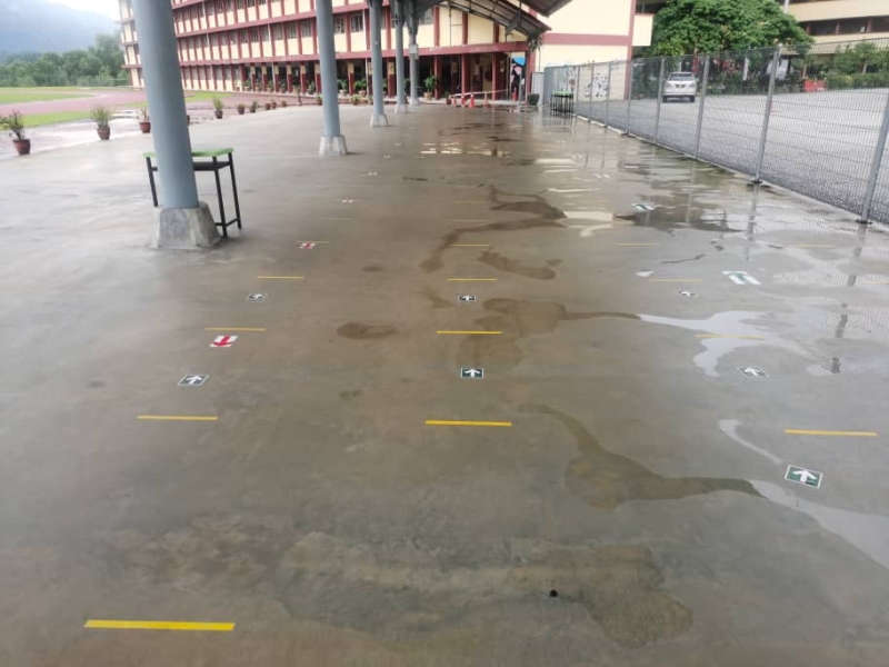 三育华小操场前的有盖司令台已经布置了黄线，让学生维持至少1公尺的社交距离。

