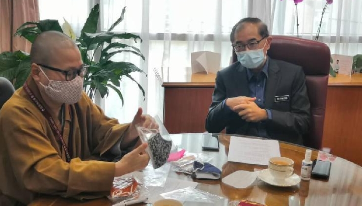 Venerable Jue Cheng delivers the fabric face masks to deputy education minister Mah Hang Soon to be distributed to needy students. SIN CHEW DAILY Venerable Jue Cheng delivers the fabric face masks to deputy education minister Mah Hang Soon to be distributed to needy students. SIN CHEW DAILY