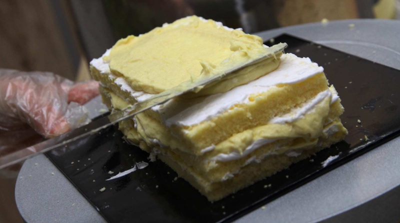 3.在海绵蛋糕薄片的两面都涂上植物性鲜奶油后，再涂上榴梿馅料。重复4层即可。