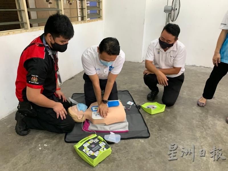 杨顺兴（中）学习如何使用AED，右是黄顺祥。