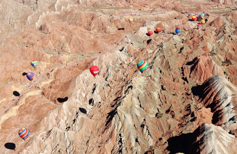 热气球悬停在甘肃省张掖市丹霞国家地质公园上空。