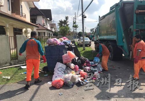 清洁工人将大量垃圾一一移上垃圾车，工作负担增加。
