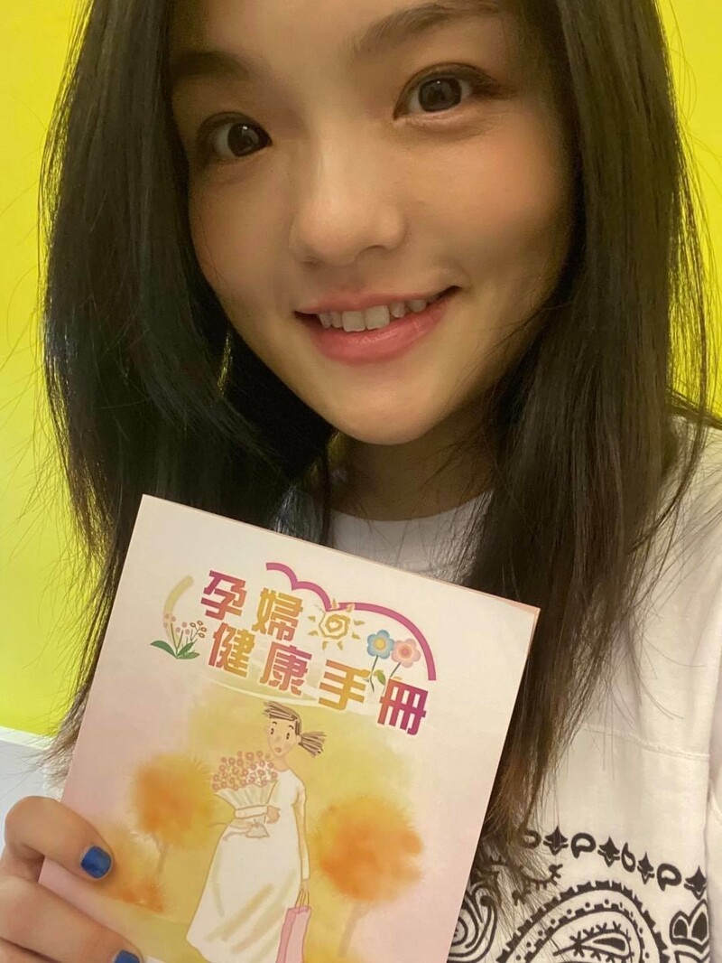 徐佳莹幸福晒出拿着孕妇健康手册的自拍。