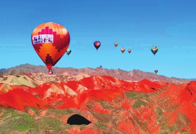 热气球飞过地质山区，构成一幅美丽的景像。（中国甘肃网-兰州晚报）