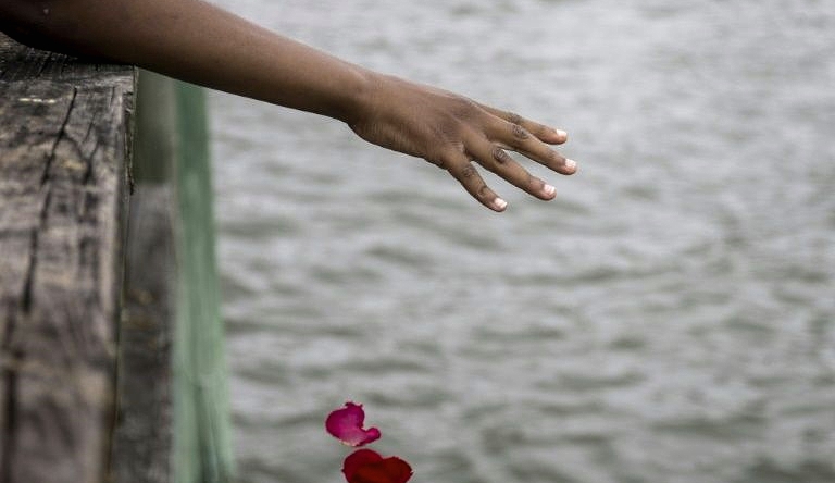 Guests take part in a flower petal throwing ceremony to honor Africans who passed away at sea during the Atlantic slave trade at the 2019 African Landing Commemorative Ceremony in Hampton, Virginia. AFP