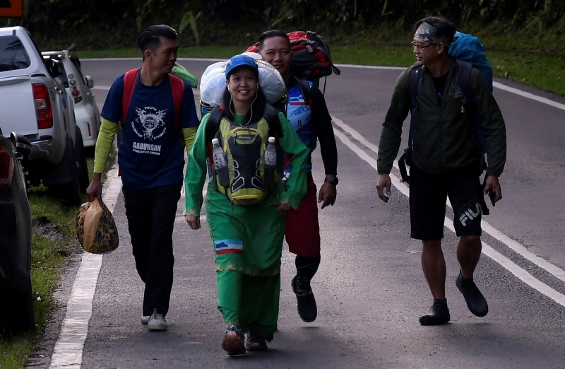 穿著绿色马来服装的哈迪娜（左二）背著一篮物品参与善举。