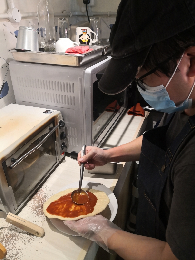 黄任廷仔细为饼皮涂上自制的番茄酱。