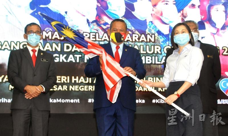 IJM Land企业社会责任部副经理叶韵莲（右）向阿敏努丁（左二）接过国旗。