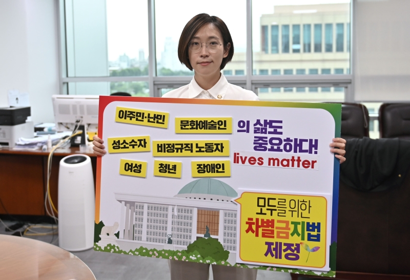 韩国国会议员郑慧英于本月中受访时在首尔的办公室，举着写上“反对一切歧视的法令”的海报，为在保守的韩国社会推动制订禁止各种歧视的法令造势。（法新社照片）