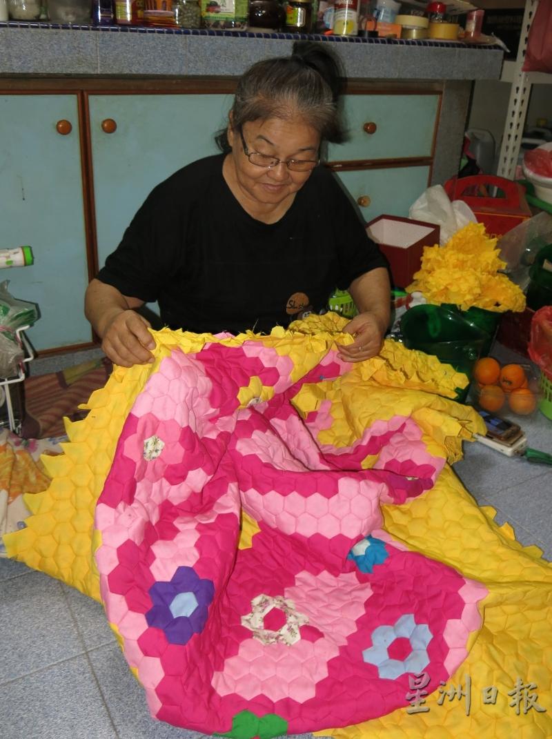 陈紫霞利用空余时间制作手工艺品，图为她在缝制百家被。