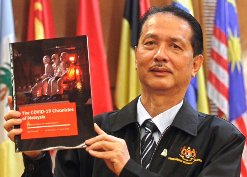 诺希山展示我国抗疫全记录的新书《马来西亚冠病抗疫纪录》。


