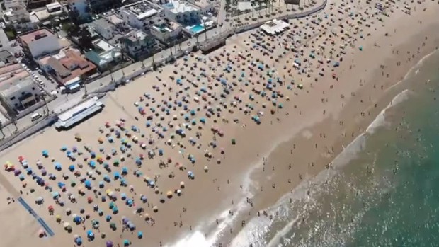 西班牙警方称赞西班牙奇皮奥纳的海滩游客在享受阳光的同时，也遵守了社交距离。（图：互联网）