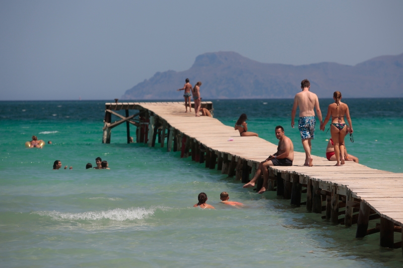 游客在西班牙马略卡岛享受海水和阳光， 该岛是英国人最爱的地中海度假地之一。英国上周突然宣布，所有从四西班牙入境的人士要隔离两周，让正在西班牙渡假和正打算前往西班牙渡假的英国人感到愕然。（美联社照片）