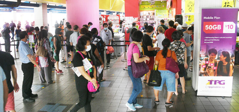 读者发现前两天在淡滨尼市中心一间手机店外有上百人排队与集聚，签买5元配套。