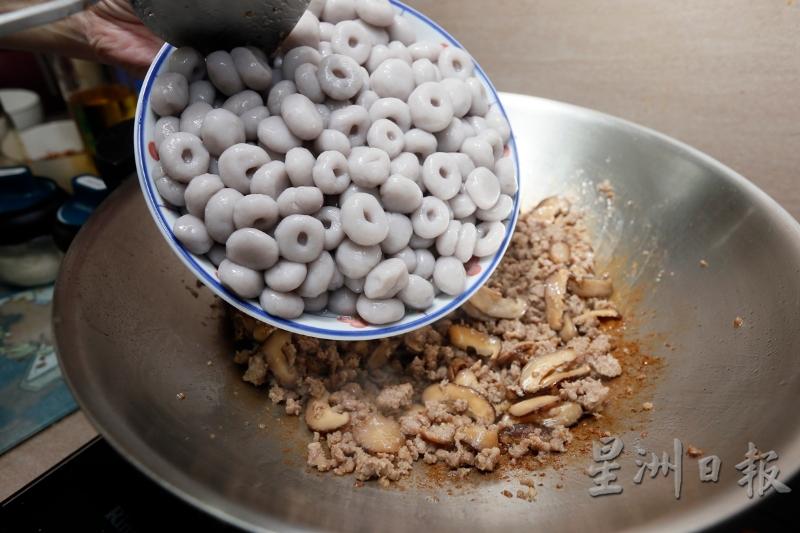 放入少许盐调味，炒一炒后再倒入冬菇继续炒。接着倒入芋头粉丸及鱿鱼丝一起炒，再加入盐及鸡精粉调味。