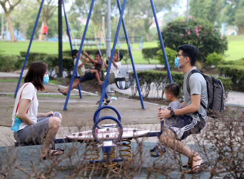 家长带着孩子到公园使用游乐设施时，也会戴上口罩。