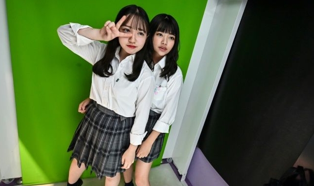 Teenagers in Tokyo pose at a Japanese photo booth known as a 