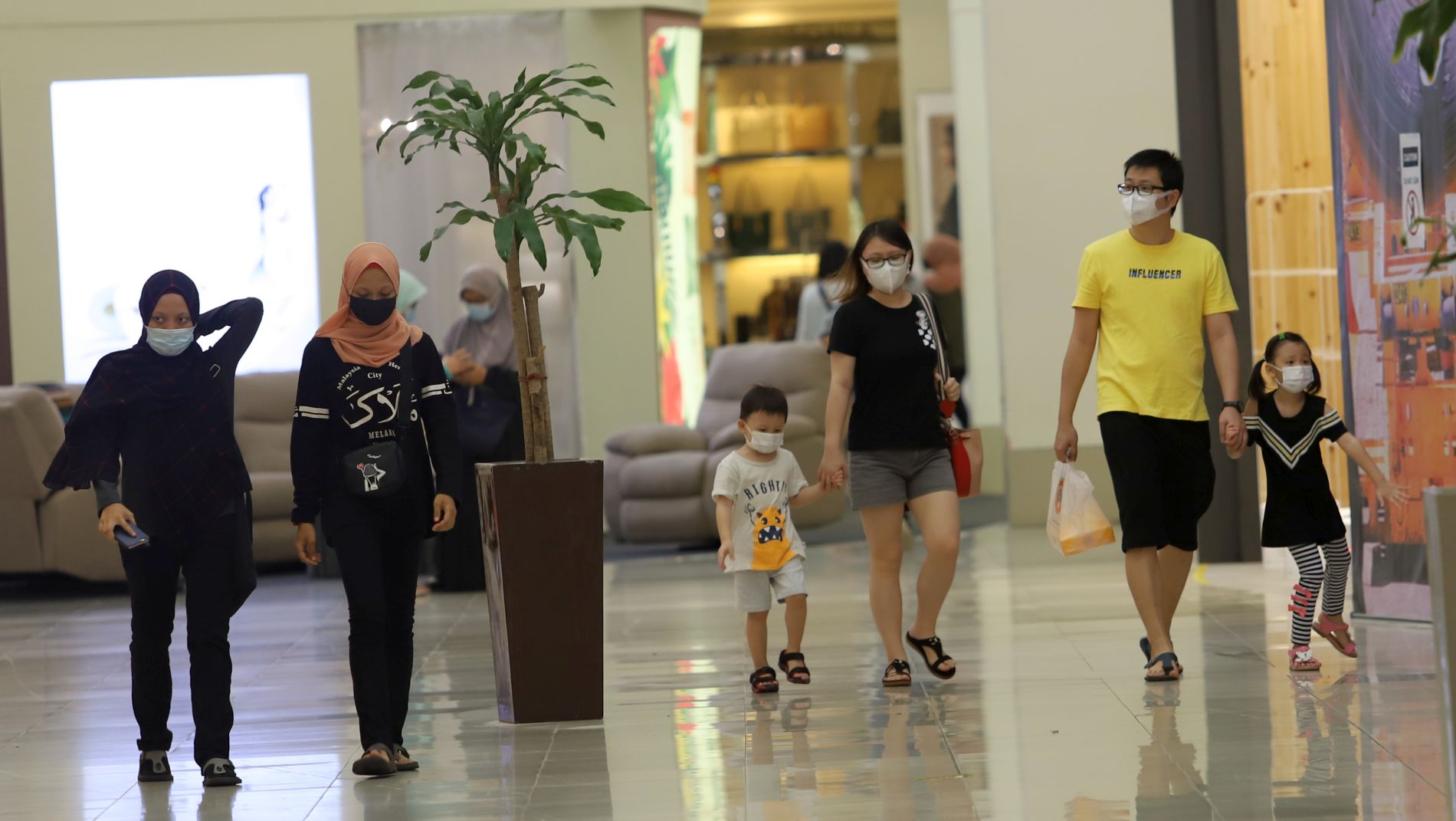 一家大小戴着口罩到商场购物，保障安全。