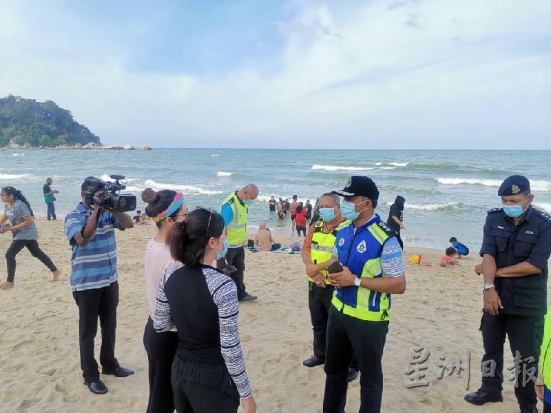 莫哈末诺(右二)于海滩巡逻时，提醒民众妥善戴上口罩并维持人身距离。