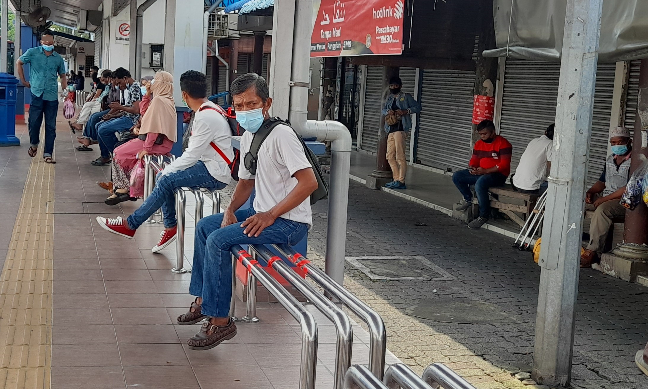 在巴士站等候的民众都戴上口罩防疫。