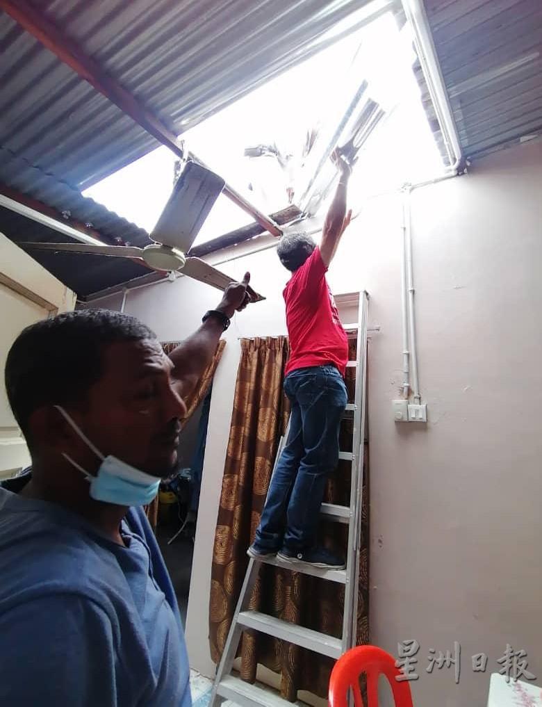 刘志良协助维修工作将锌片搬至屋顶。