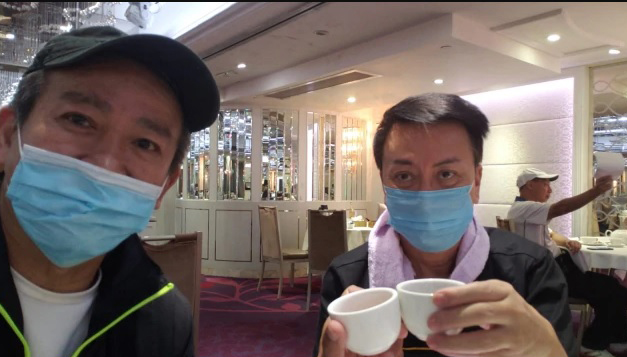 麦德罗（左）与刘少君戴着口罩手举茶杯庆祝冠病痊愈。