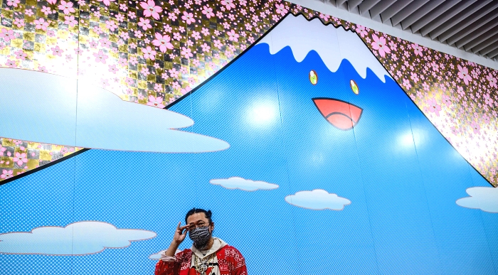 Artist Takashi Murakami stands in front of his work Artist Takashi Murakami stands in front of his work