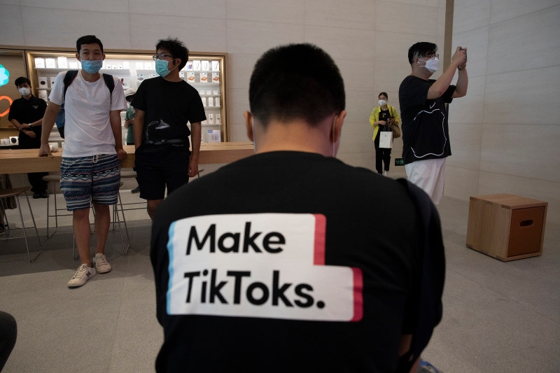 特朗普放话禁止抖音后，一名男子周五身穿声援抖音的T恤现身北京苹果商店以示支持。（美联社照片）