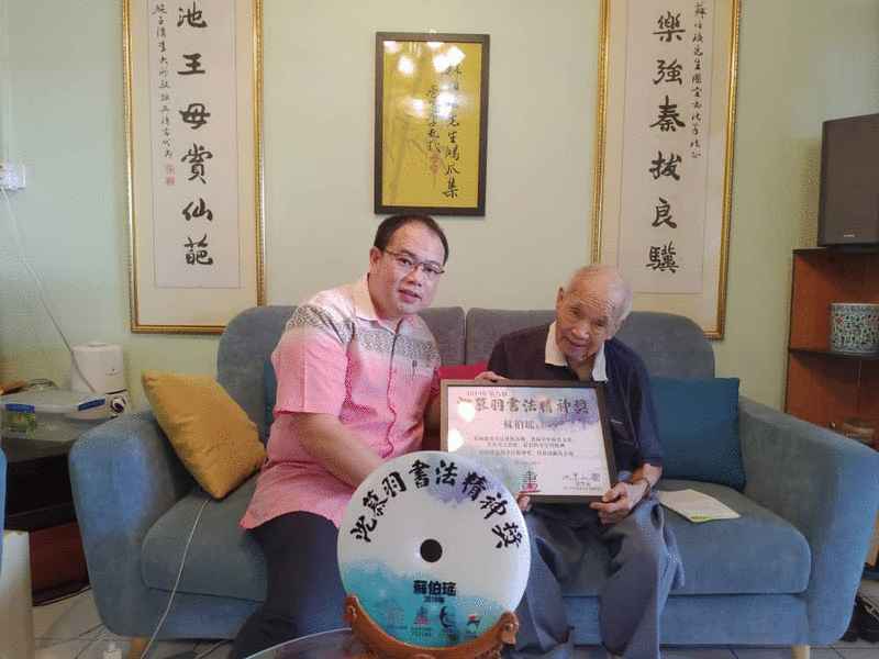 薛君毅移交奖项予老师苏伯瑶（右） 。