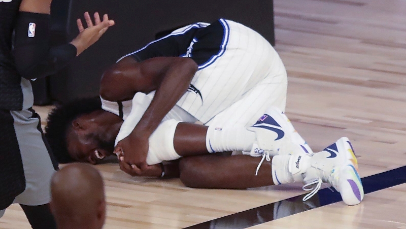 艾萨克在比赛中遭遇左膝前交叉十字韧带撕裂重伤，为NBA复赛后首名重伤离场的球员。图为艾萨克蒙伤后双手抱膝哀嚎。（美联社照片）
