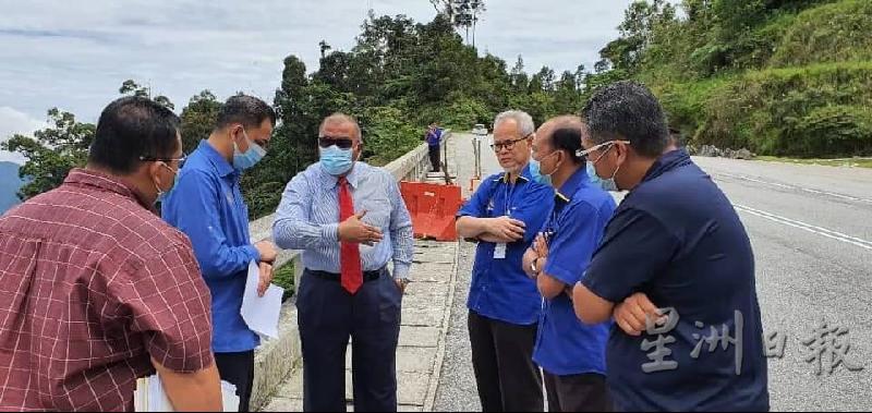 祖基菲里（左三）听取近打工程局工程师卡玛阿芬迪（右二起）及霹雳州工程局局长罗斯兰汇报现场土崩情况。

