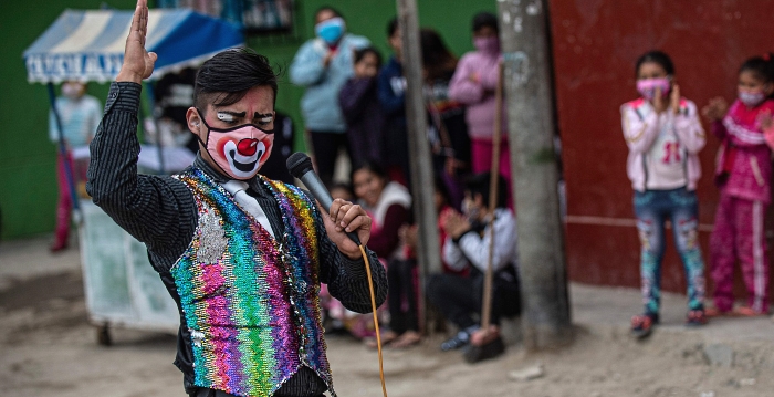 A clown wearing face mask performs at Puente Piedra district on the outskirts of Lima during the COVID-19 pandemic. Circuses in Peru remain closed due to the pandemic, leading this group of clowns traveling in their mototaxis to perform in the streets of Lima. AFP