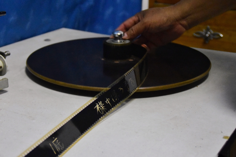 在马鸣电影馆内，朱生荣整理《碟中谍3》的胶片拷贝。（图：新华社）  