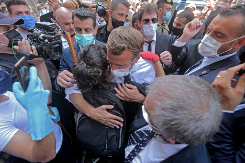 法国总统马克龙到访贝鲁特杰美扎期间给予一名女子一个拥抱，勉励对方保持坚强。（法新社照片）
